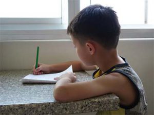 enfant qui travaille seul à la maison